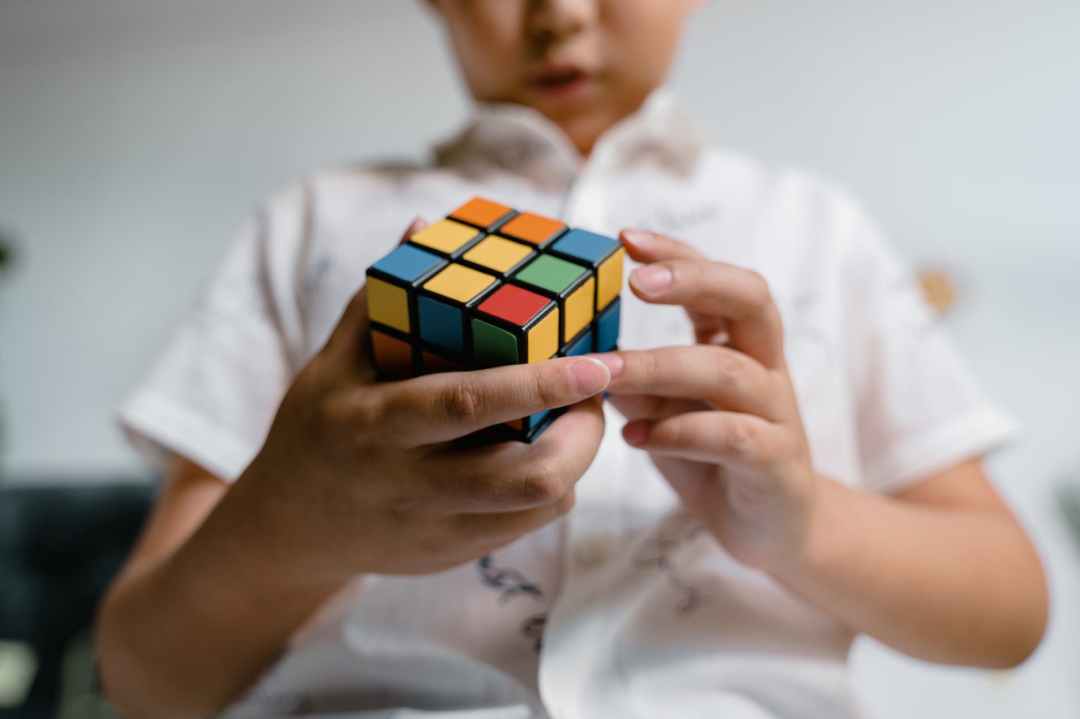 close up photo of a child solving a rubik s cube