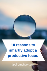 Hand holding a magnifying glass. Text: 10 reasons to smartly adopt a productive focus, tipsfromsharvi.com.